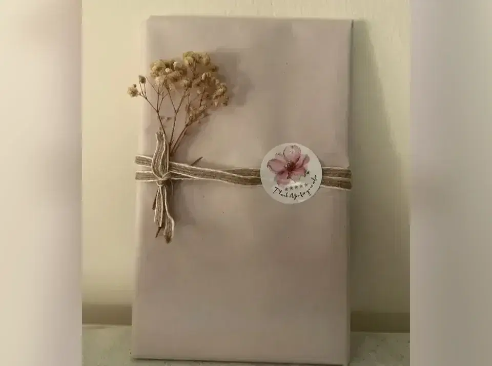 הספר שקופה עטוף כמתנה עם זר פרחים יבשים