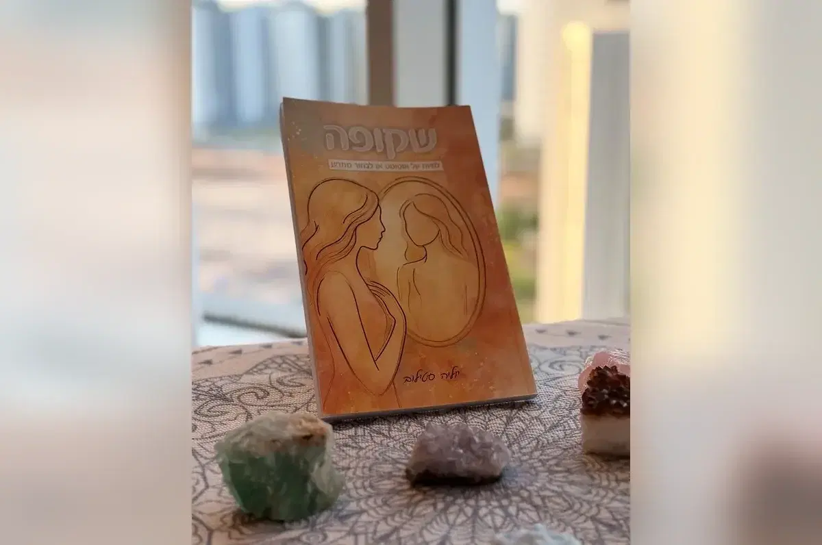 הספר שקופה על שולחן עם אבני קריסטל