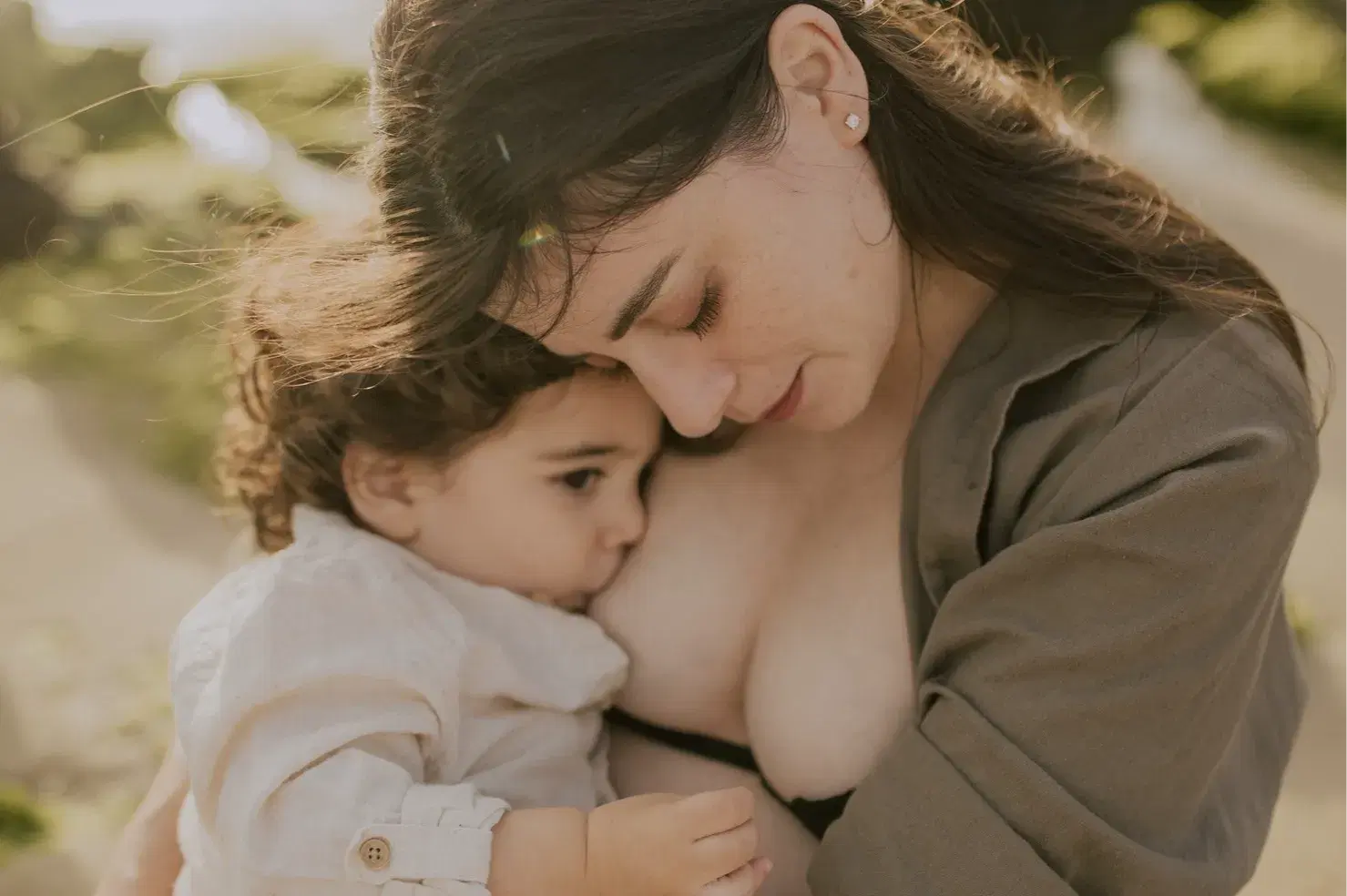 אמא מניקה תינוק על רקע חוף הים אמא מניקה תינוק על רקע חוף הים